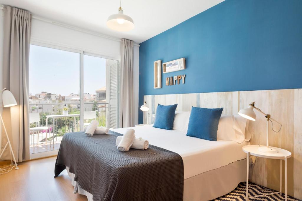 a bedroom with a large bed with blue walls at Sitges Group Soul in Sitges