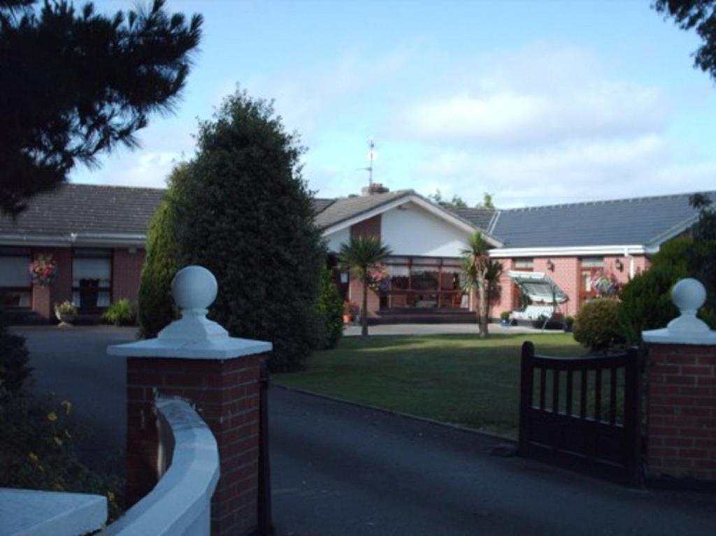 una valla frente a una casa con un edificio en Evergreen Bed & Breakfast, en Swords