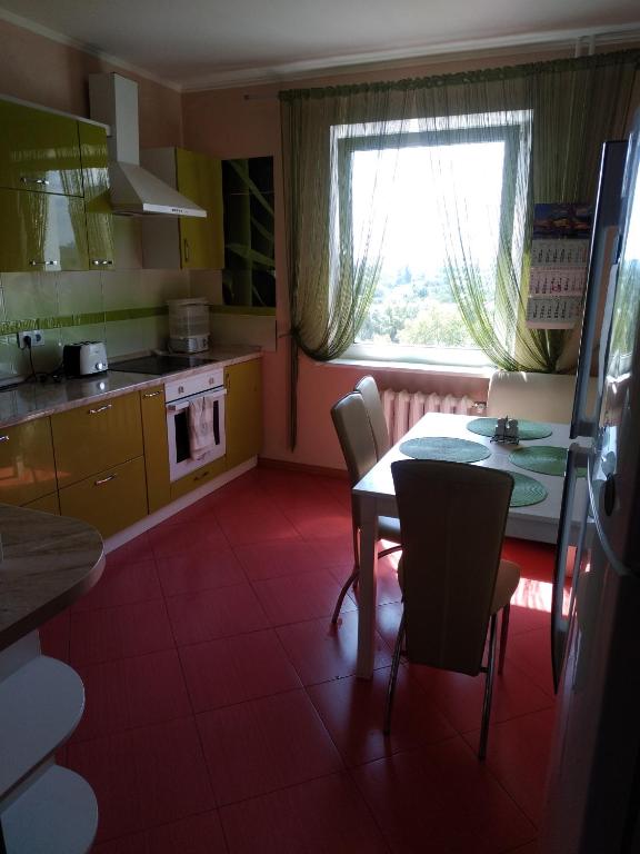 キーウにあるApartment on Vaschenko 1のキッチン(テーブル、椅子付)、窓