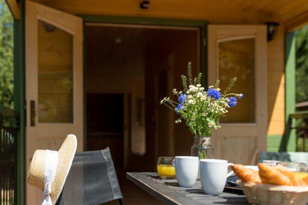 a table with a vase of flowers and bread at Rives Nature in La Gacilly