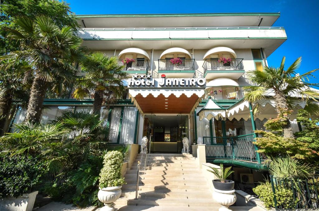 un hôtel avec des palmiers devant un bâtiment dans l'établissement Hotel Janeiro, à Caorle