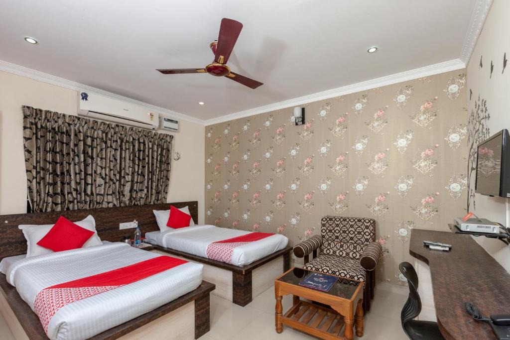 a hotel room with two beds and a desk at Maruthi Residency in Chennai