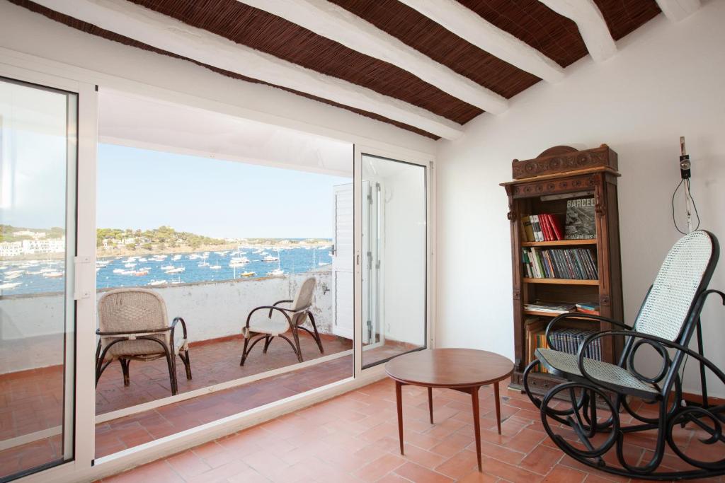 een kamer met een balkon met stoelen en een tafel bij Akira Flats Cadaqués Llané in Cadaqués