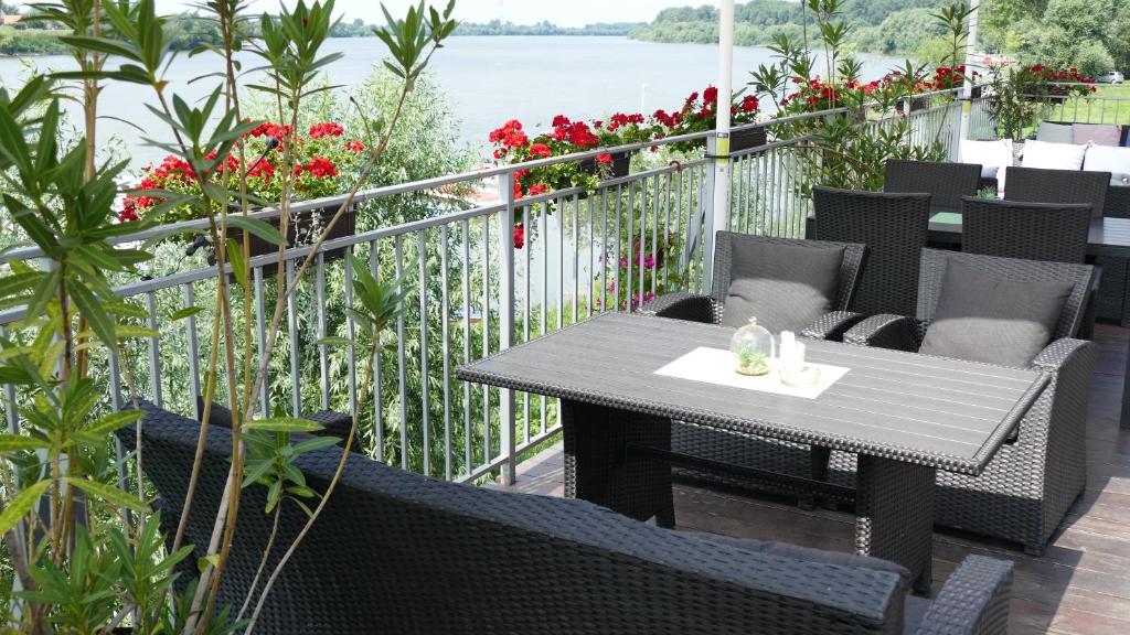 una mesa y sillas en un balcón con flores en B&B Posejdon, en Sremska Mitrovica