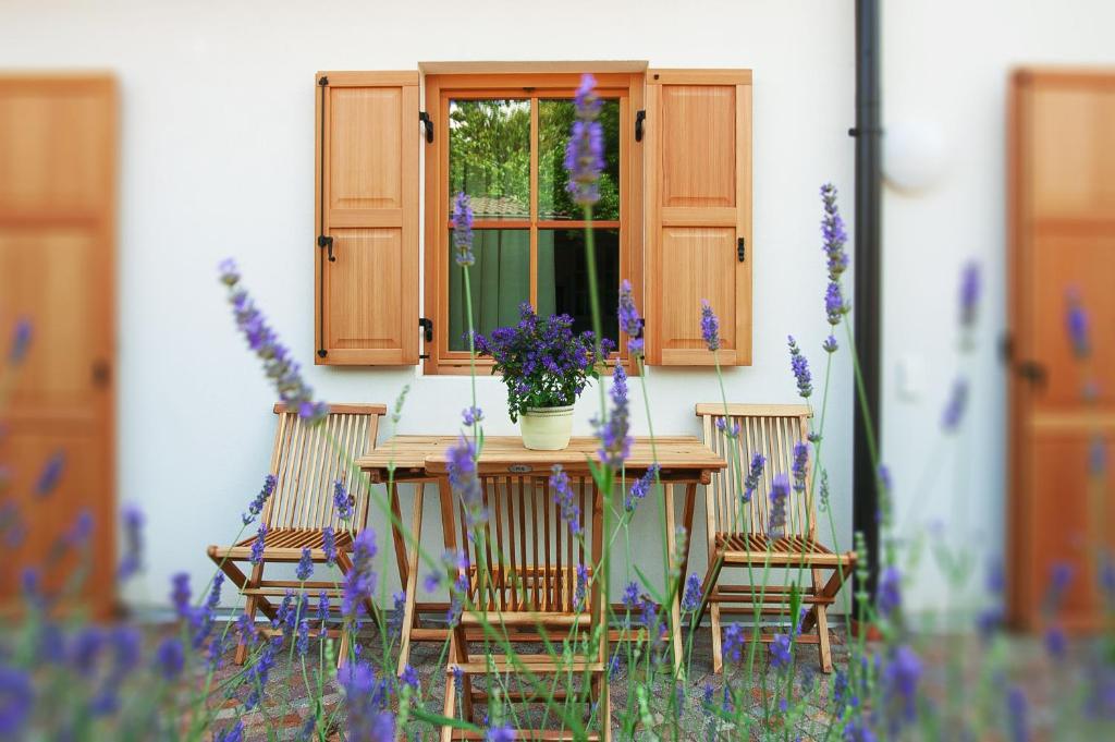 een tafel en stoelen voor een raam met bloemen bij Obstbauernhof Bundschuh in Appiano sulla Strada del Vino