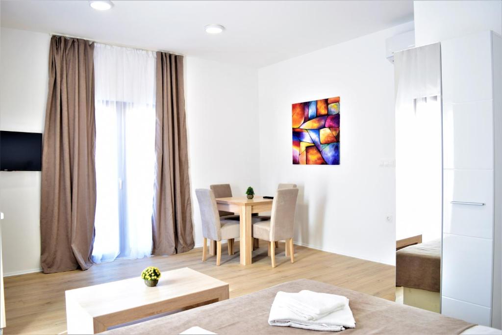 uma sala de estar com uma mesa e uma sala de jantar em Martinović Rooms em Budva
