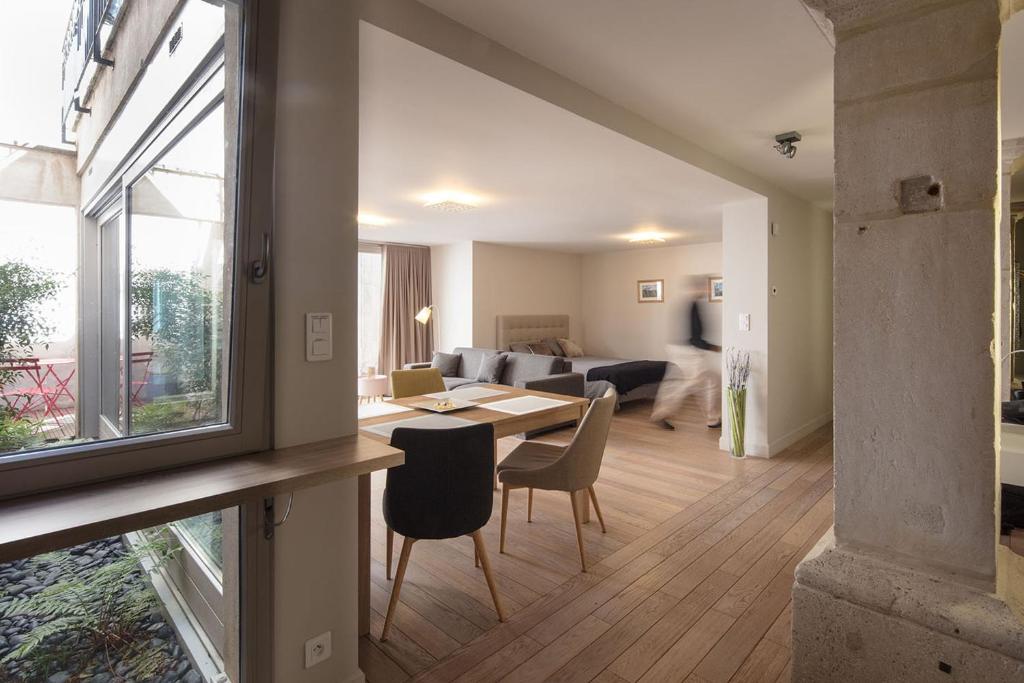 a living room with a table and chairs and a living room at L'Aparté in Nancy