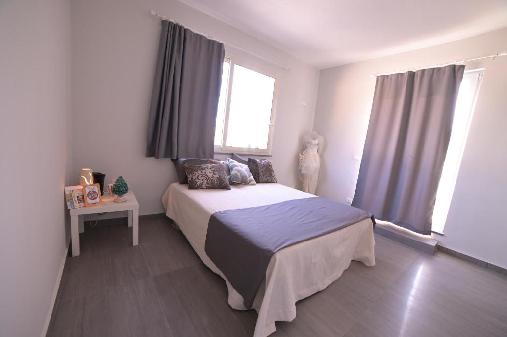 a bedroom with a bed and a window at STANZINA DELLA BARONESSA in Carini
