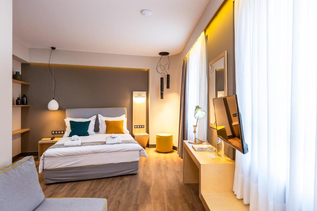 Habitación de hotel con cama y TV en St. Bjur Suites, en Atenas