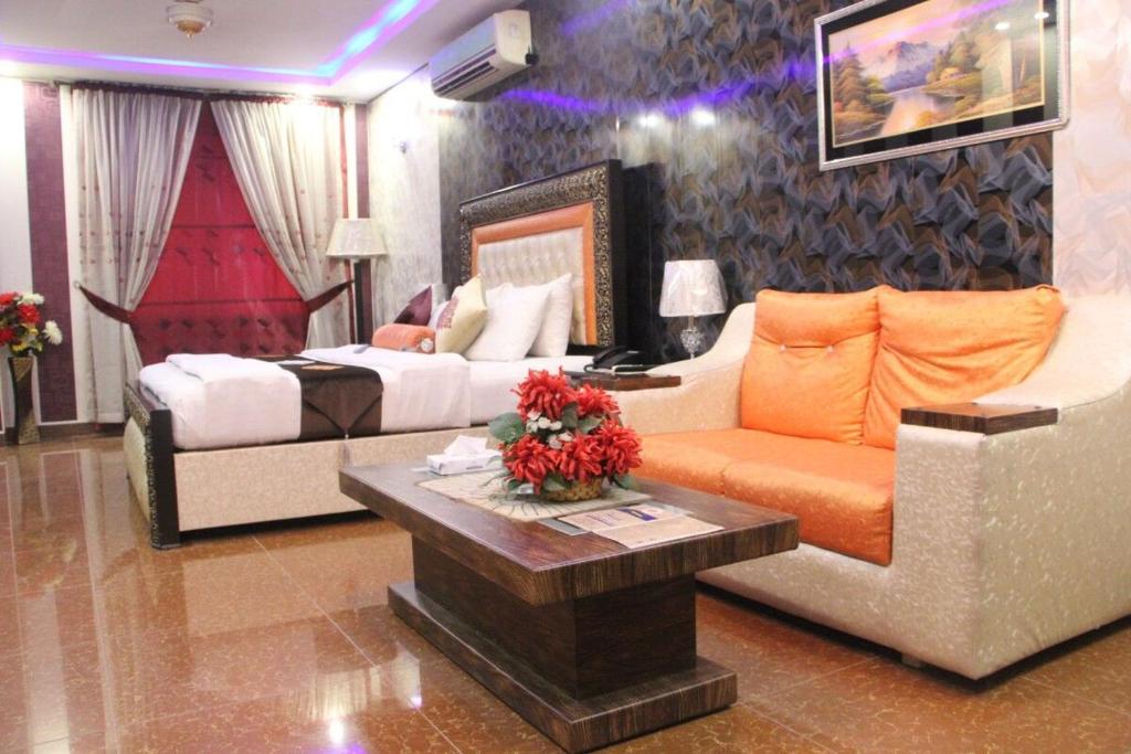 uma sala de estar com um sofá e uma cama em Hotel The Leschanze em Lahore