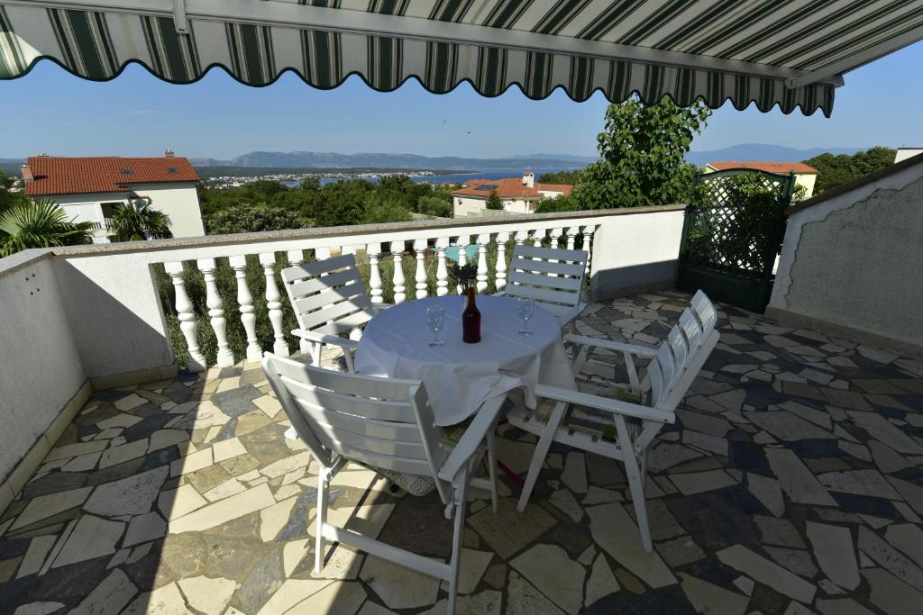 una mesa y sillas en un patio con sombrilla en Apartments Berny en Sveti Vid-Miholjice