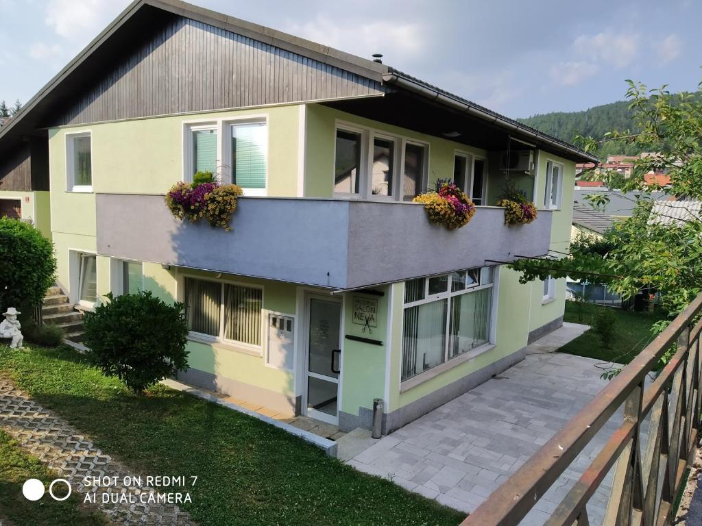 uma casa com uma varanda com flores em Apartma JERMAN - Cerknica em Cerknica