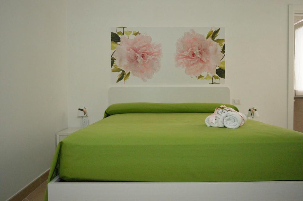 ein Schlafzimmer mit einem grünen Bett mit zwei Handtüchern darauf in der Unterkunft Ica house in Castellammare di Stabia