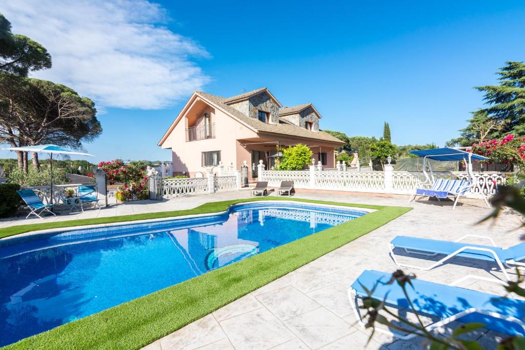 a swimming pool in front of a house at HomeHolidaysRentals Corts in Tordera