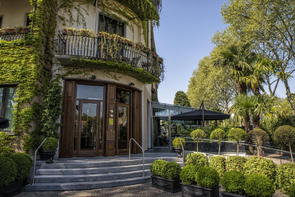 a building with a door and stairs in front of it at Hotel de la Ville Monza - Small Luxury Hotels of the World in Monza