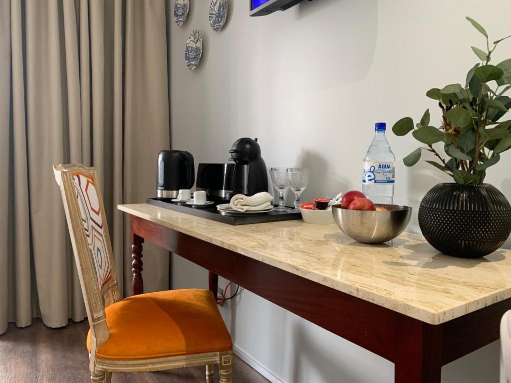 un tavolo con un cesto di frutta e un vaso di Central - São Pedro Boutique a Funchal