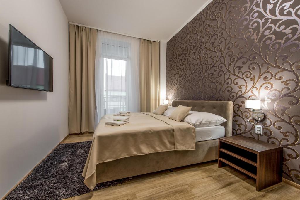 1 dormitorio con 1 cama grande y TV en Hotel Black Horse, en Prešov