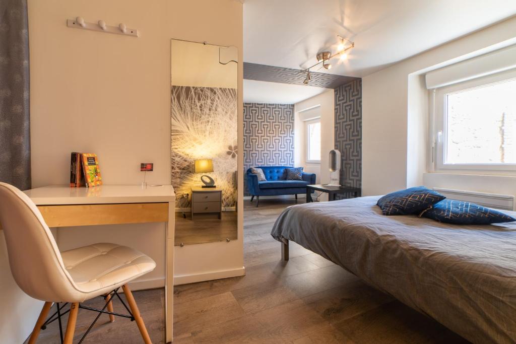 洛特河畔新城的住宿－Le Félix Grat - LAVALOC，一间卧室配有一张床、一张桌子和一把椅子