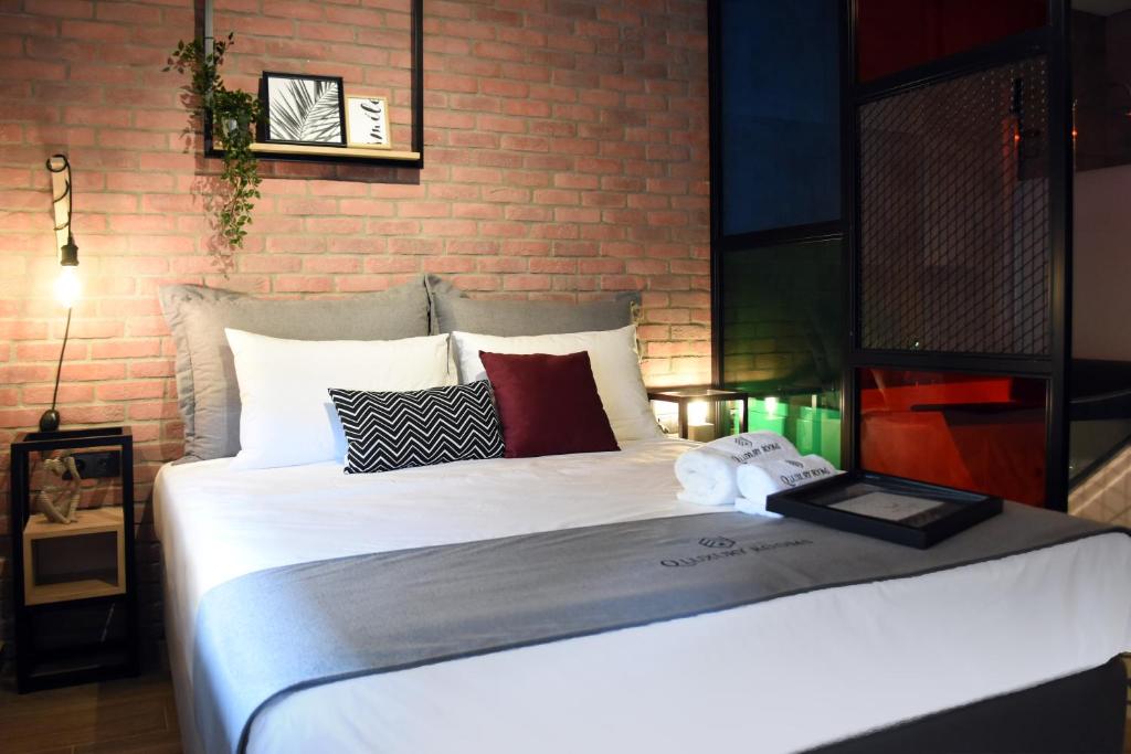 a bedroom with a large bed with a brick wall at Q Luxury Rooms in Thessaloniki