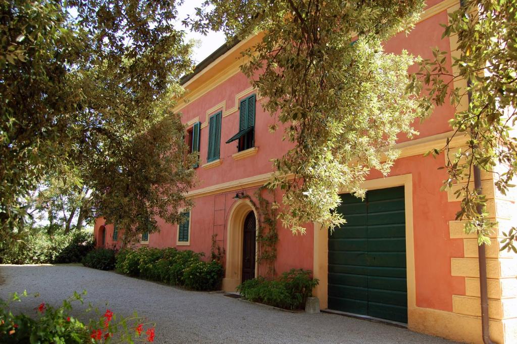 a pink house with a garage and a driveway at Podere Doganelle in Giuncarico