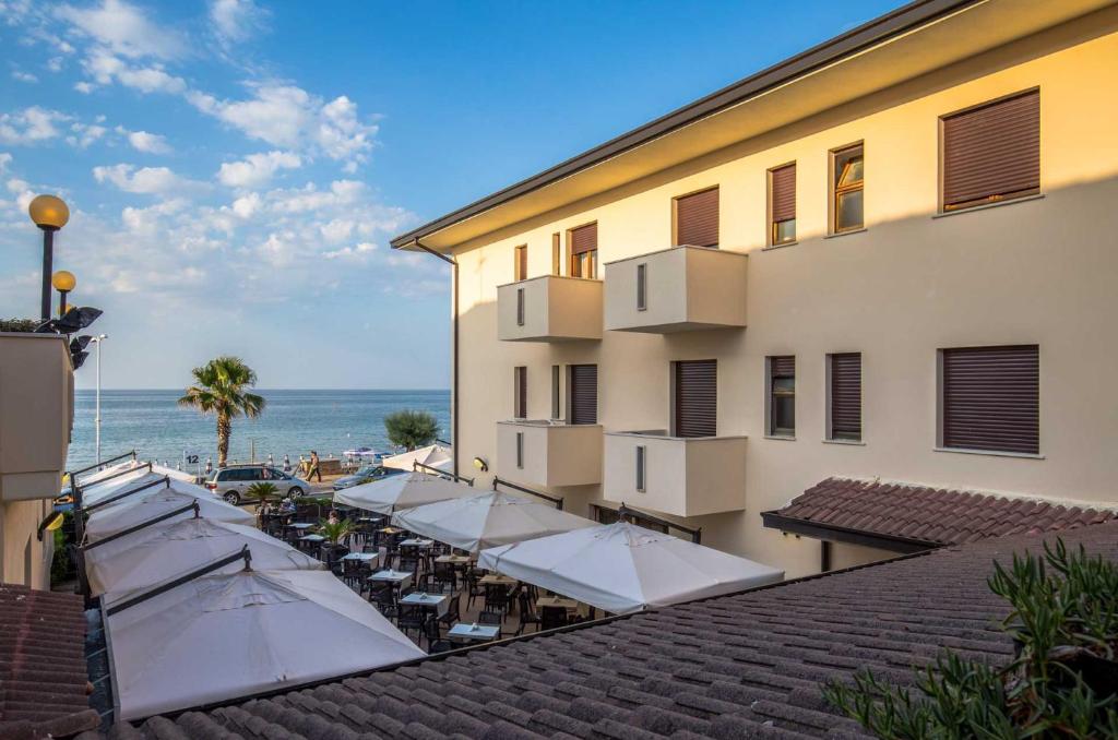 a hotel with tables and chairs and the ocean at Hotel Calgary in Casalbordino