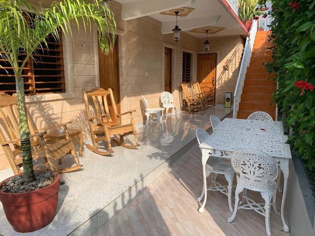 a patio with a table and chairs and a tree at Casa Colonial Familia Azcuy in Viñales