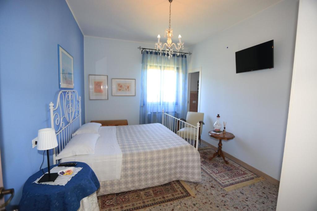 una camera blu con un letto e un lampadario a braccio di B&B La casa di g.g. a Grottammare