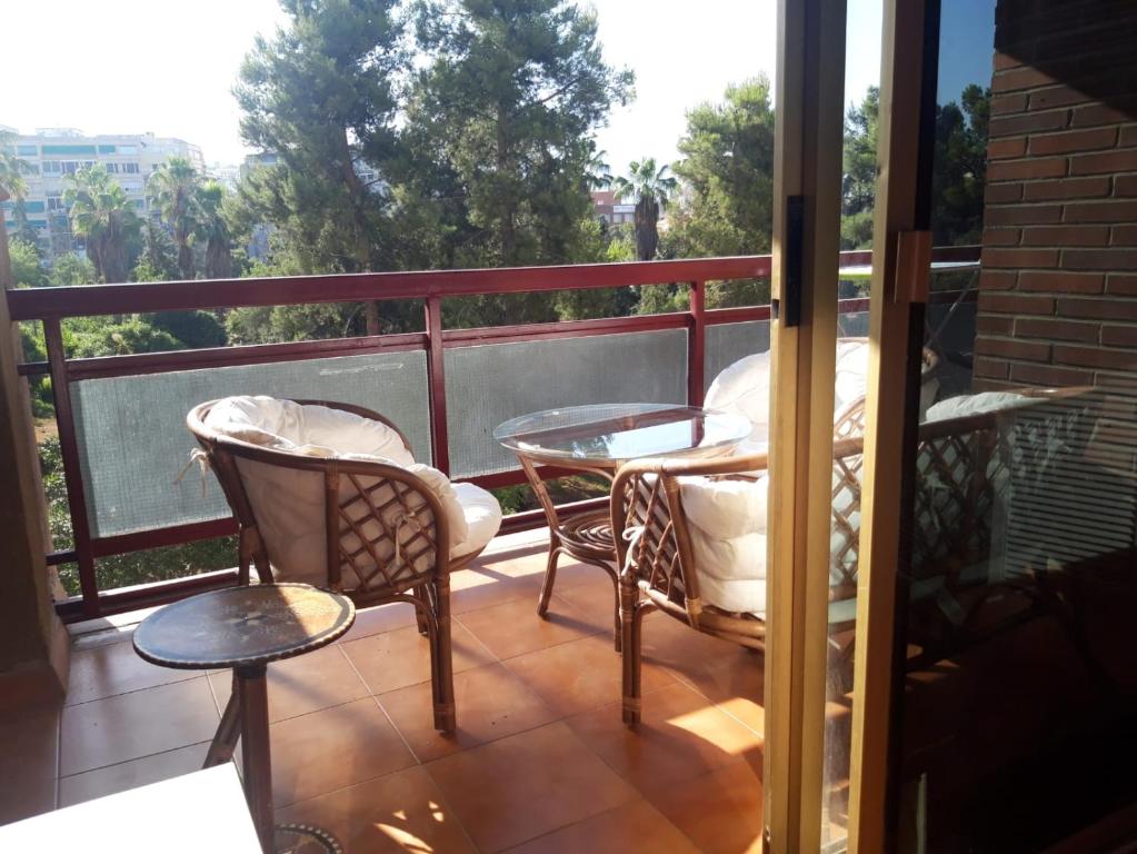 un balcón con 2 sillas y una mesa en un porche en Habitaciones amplias en el Centro de Granada, en Granada