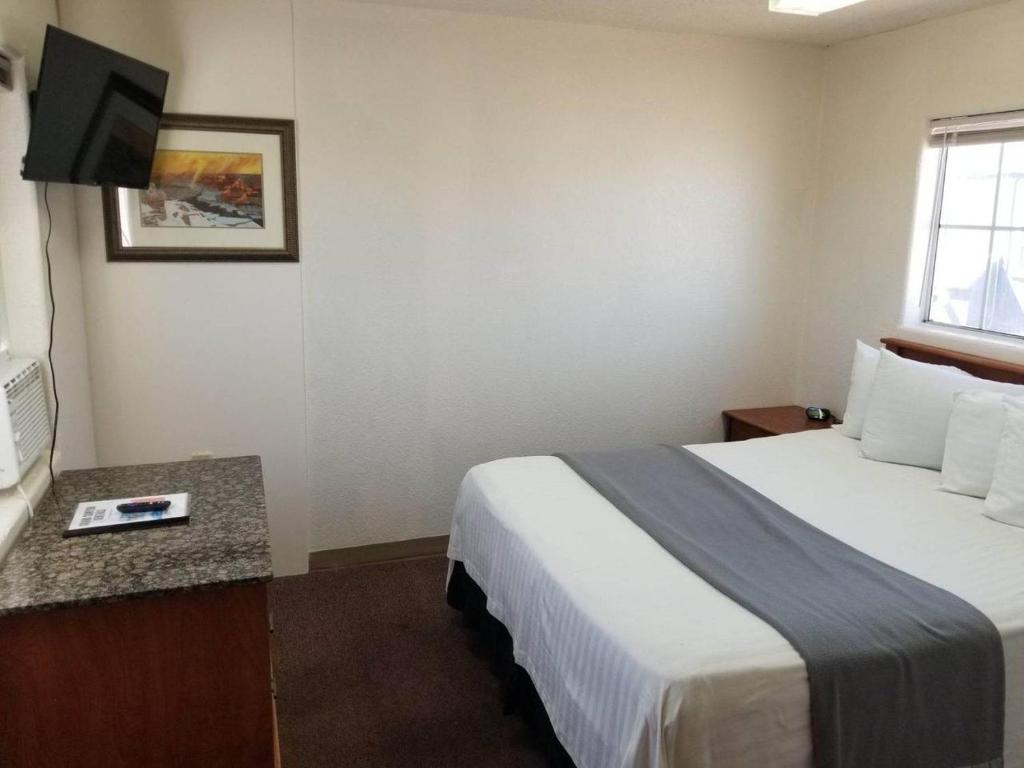 ein Hotelzimmer mit einem Bett und einem Flachbild-TV in der Unterkunft 068B Cozy Studio Grand Canyon South Rim Sleeps-2 in Valle