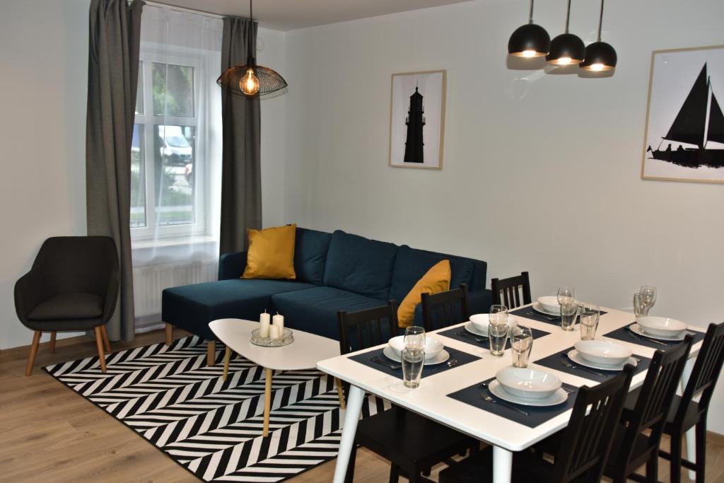 - un salon avec une table et un canapé bleu dans l'établissement Przystań w Pucku, à Puck