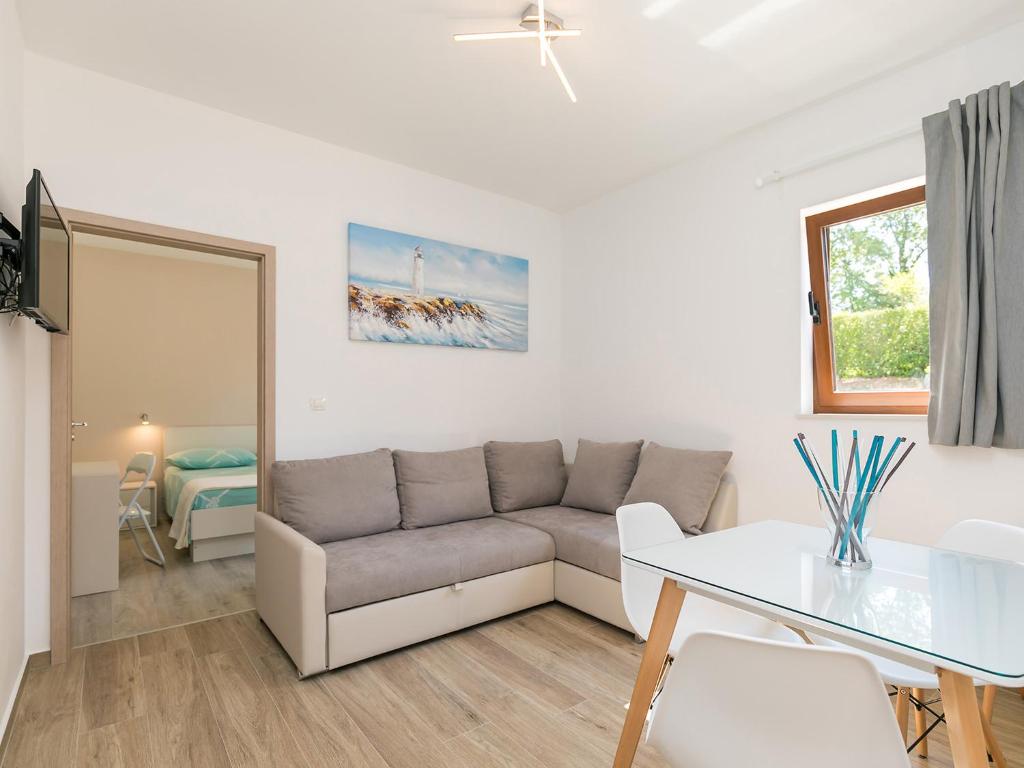 a living room with a couch and a table at Apartment Stefano - free wine&spirit tasting in Višnjan
