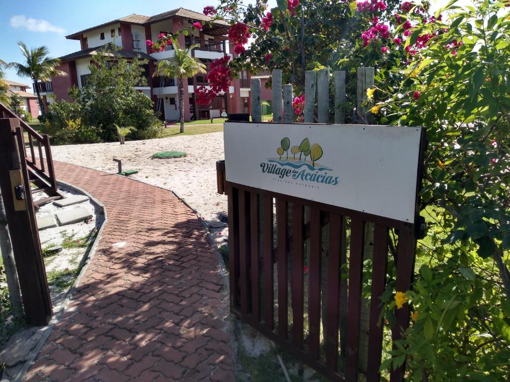 a sign on a fence in front of a yard at PRAIA DO FORTE - CONDOMINIO VILLAGE DAS ACACIAS - PISCINAS NATURAIS in Praia do Forte
