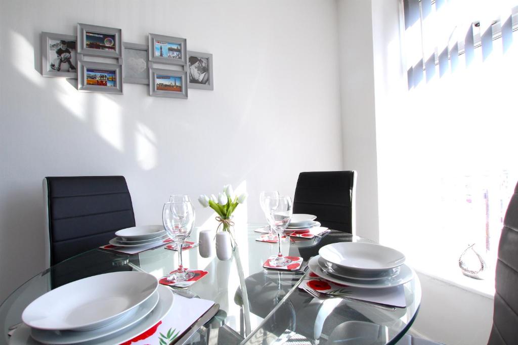 une salle à manger avec une table en verre et des chaises noires dans l'établissement Fabrik Apartments - 66 Central Drive, à Blackpool