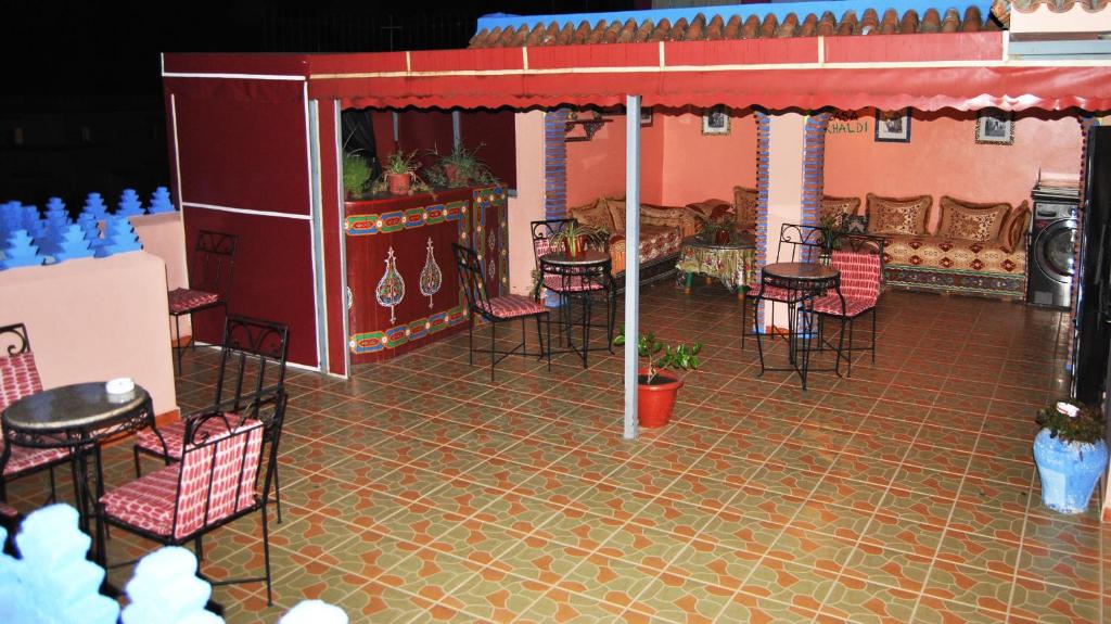 a room with a table, chairs, and tables in it at Hotel Casa Khaldi in Chefchaouen