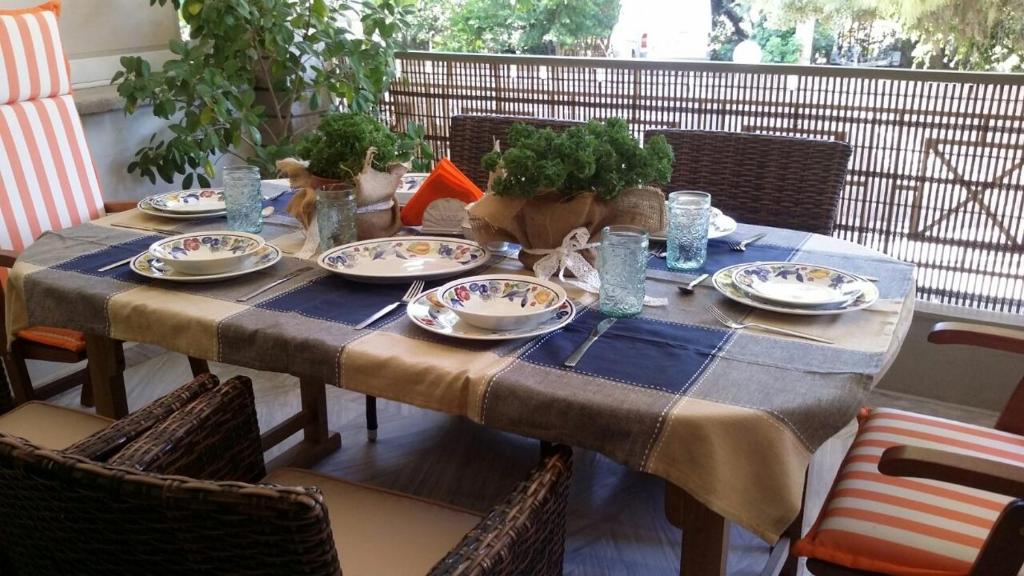 einen Tisch mit einem blauen Tischtuch und Platten darauf in der Unterkunft Sandy's apartment in Antikes Epidauros