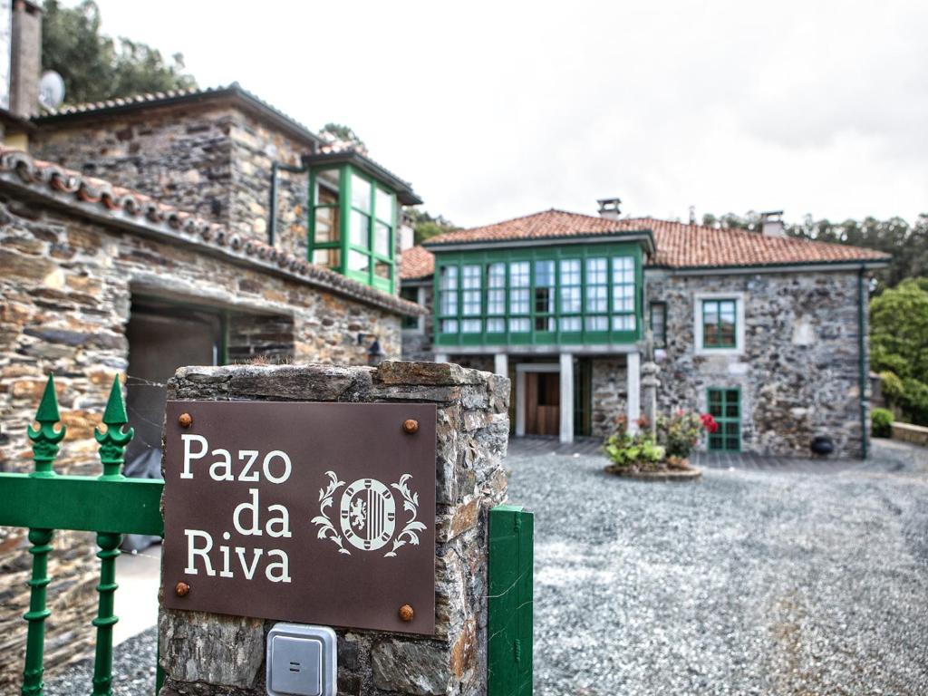 un panneau devant une maison avec un bâtiment dans l'établissement Pazo da Riva - Casa dos Arcos, à Valdoviño