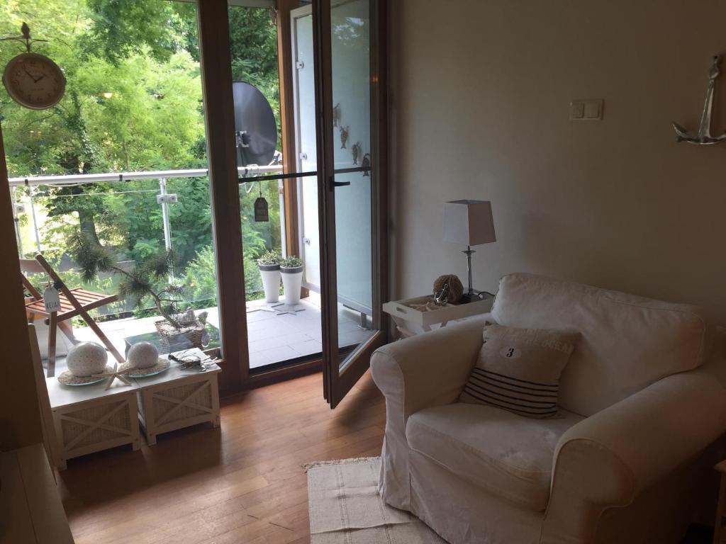 a living room with a chair and a sliding glass door at Lux apartament Poznań, ul. Mostowa 19 D/5 in Poznań