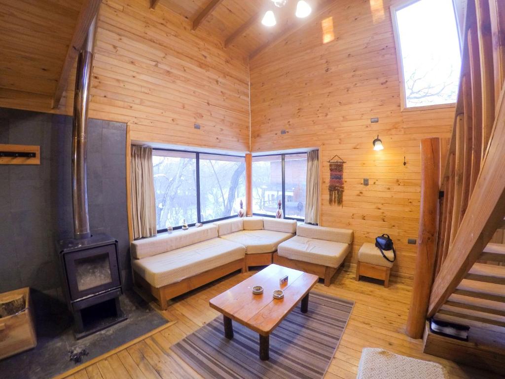 Cabaña las trancas في Nevados de Chillan: غرفة معيشة مع أريكة ومدفأة