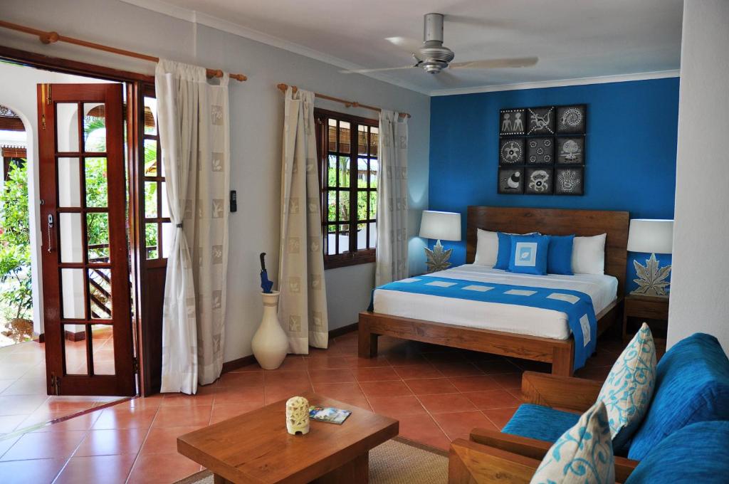 una camera con letto e divano di Villas de Mer a Grand'Anse Praslin