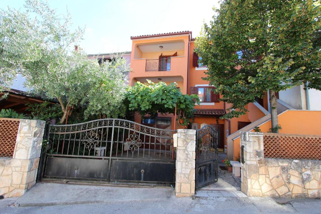 a black gate in front of a house with trees at Apartments Grace in Rovinj