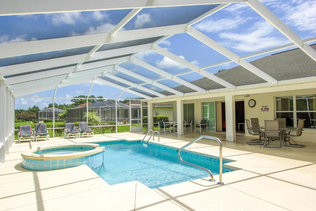 a patio with a swimming pool with a retractable roof at North Timucuan Trail Villa 1208 in Hernando
