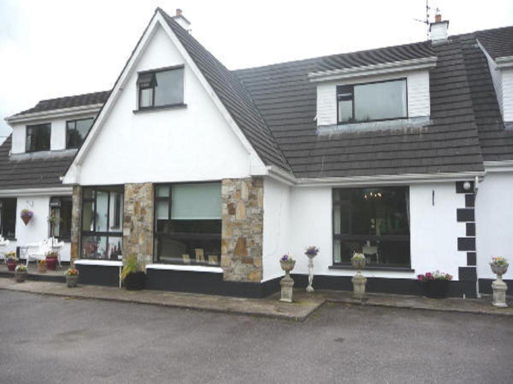 a white house with a black roof at Carrigshane House in Midleton