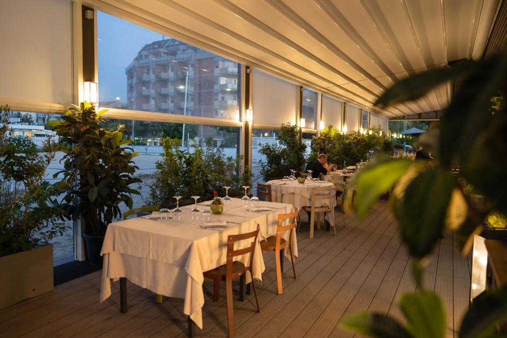 a restaurant with tables with white table cloths on a balcony at Hotel Salus in Pescara