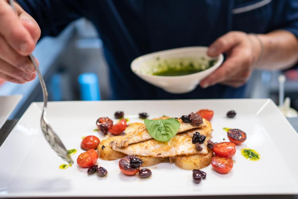 a person eating a plate of food on a table at Hotel Salus in Pescara