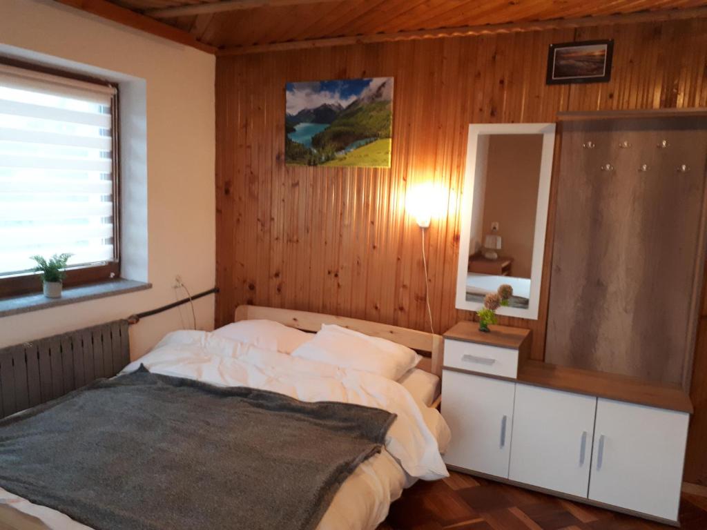 a bedroom with a bed and a large mirror at Pokoje u Marysi in Szaflary