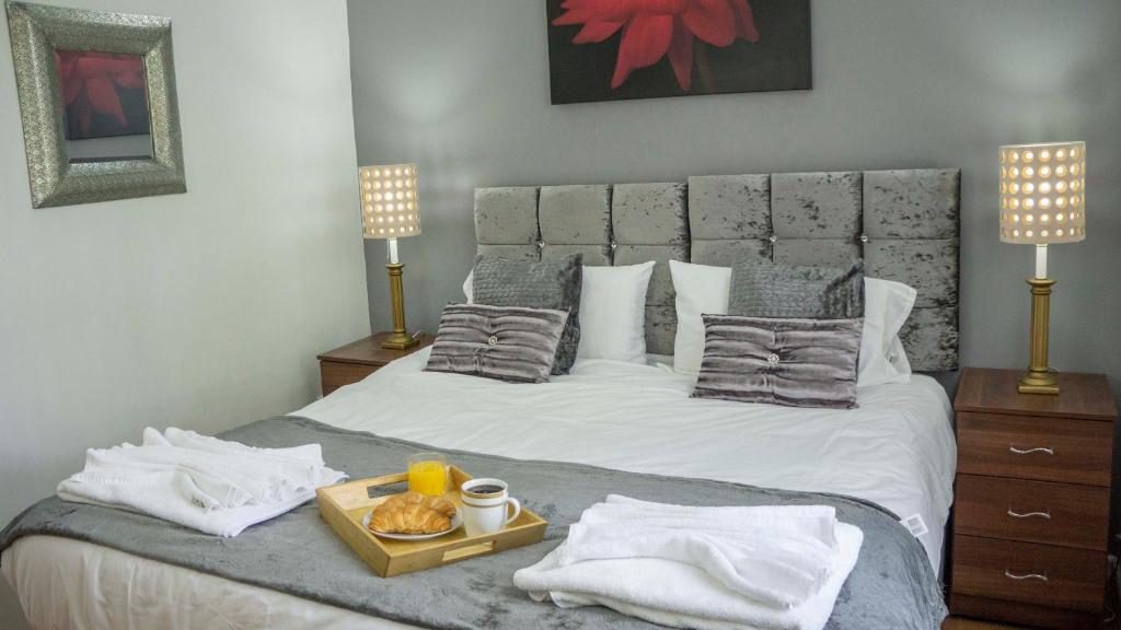 a bedroom with a bed with a tray of food on it at Comfort Stay Apartments in Birmingham