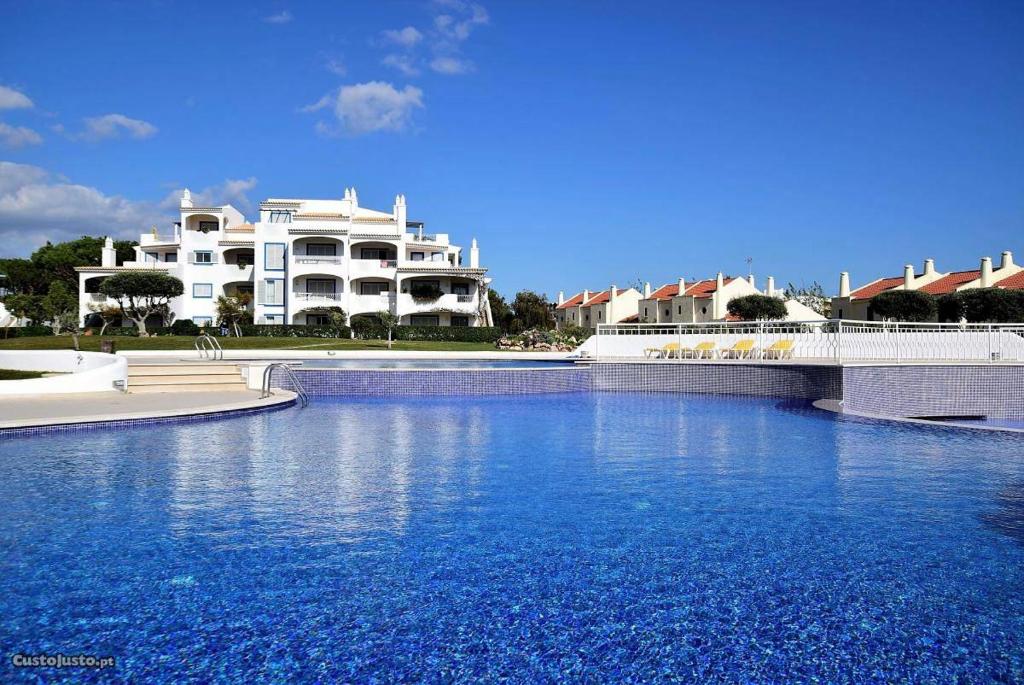 une grande piscine en face d'un grand bâtiment blanc dans l'établissement Charming Apartment with Private Garden & Pool, à Vilamoura
