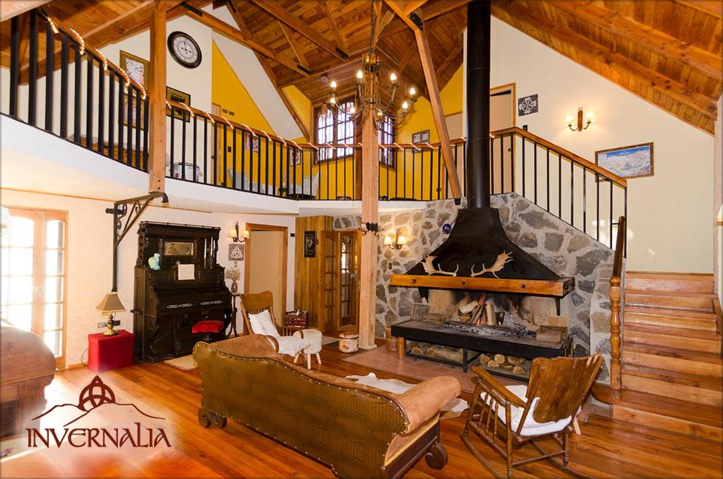a large living room with a fireplace and a staircase at Refugio Invernalia in Las Trancas