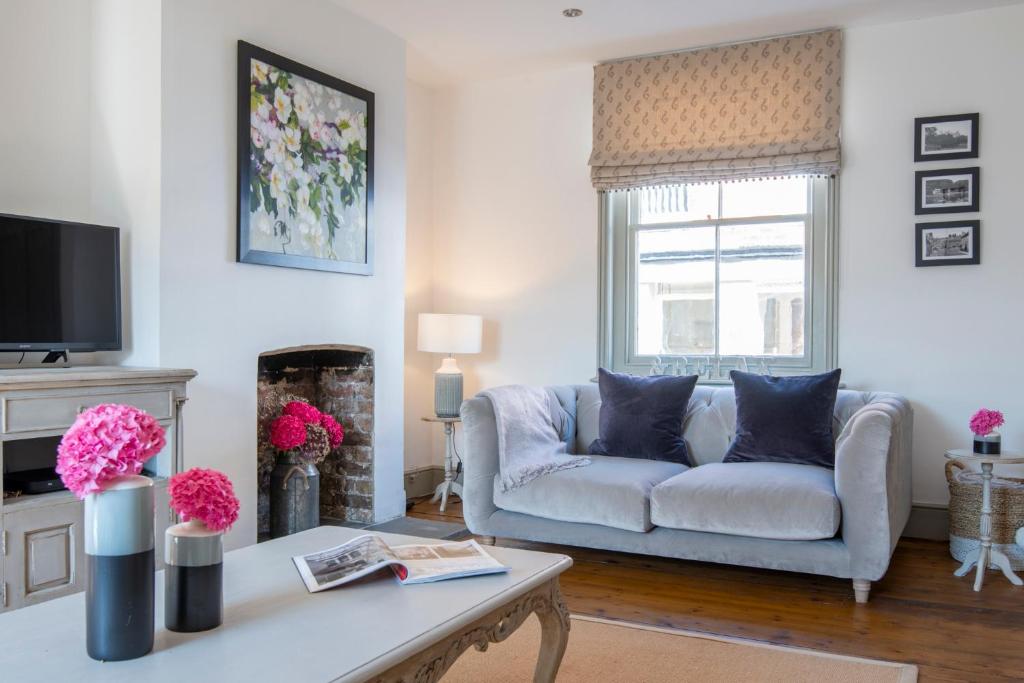 a living room with a couch and a fireplace at A Luxury Retreat in the Heart of Arundel in Arundel