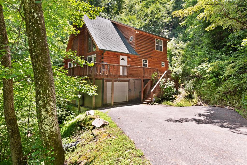 a wooden house with a garage in the woods at Hawks Landing in Sylva